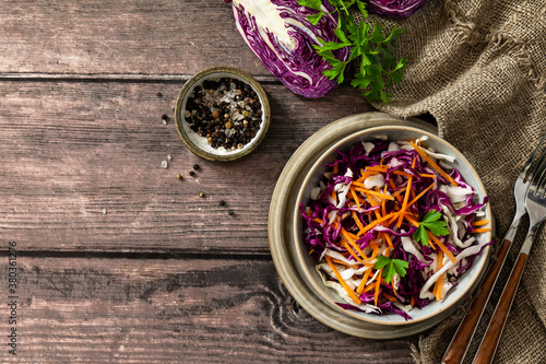 Salad Cole Slaw. Autumn Cabbage salad in a bowl on a rustic wooden table. Flat lay top view. Copy space.