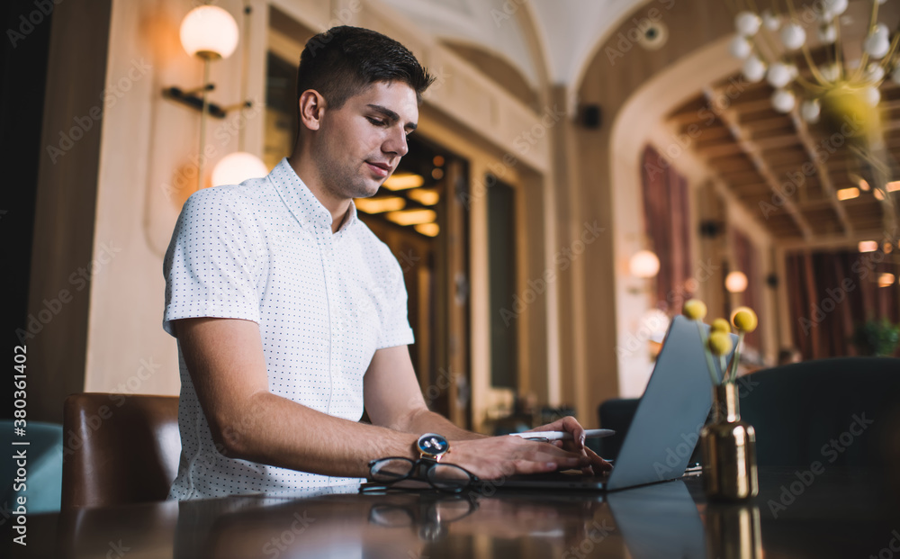 Focused man using laptop in restaurant Focused man using laptop in restaurant
