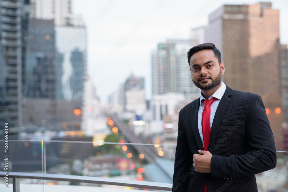 Young bearded Indian businessman against view of the city
