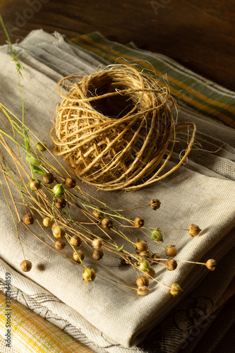 Bunch of dry flax plants and a skein of rope on a linen cloth