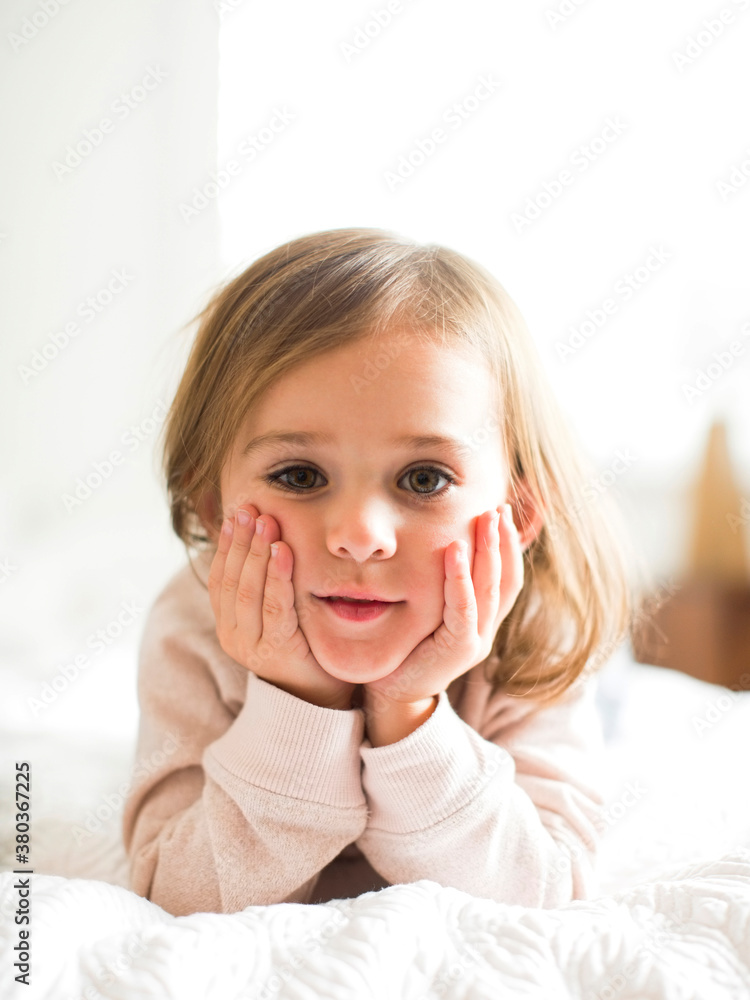Portrait of girl (4-5) lying on bed