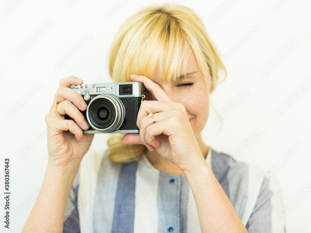Studio shot of woman holding camera Studio shot of woman holding camera