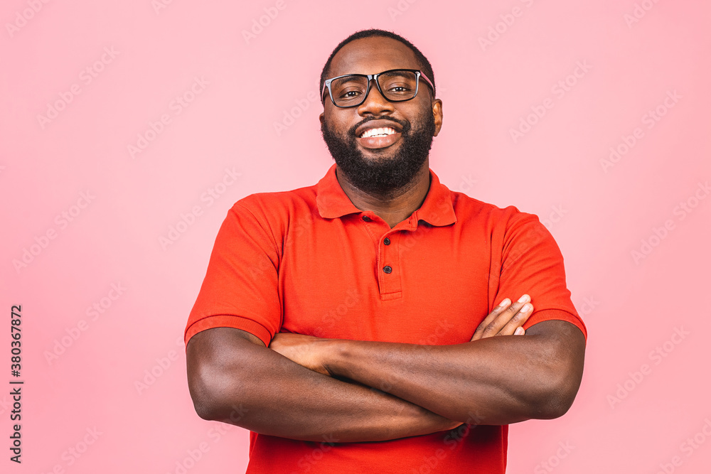 Portrait of a cheerful young african american man keeping arms crossed and smiling standing against pink background. Portrait of a cheerful young african american man keeping arms crossed and smiling standing against pink background.
