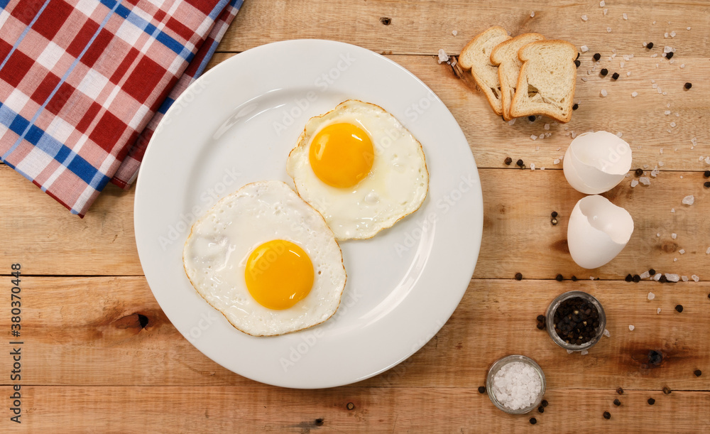 fried eggs, on a white plate, on wooden background. Top Wiew fried eggs, on a white plate, on wooden background. Top Wiew