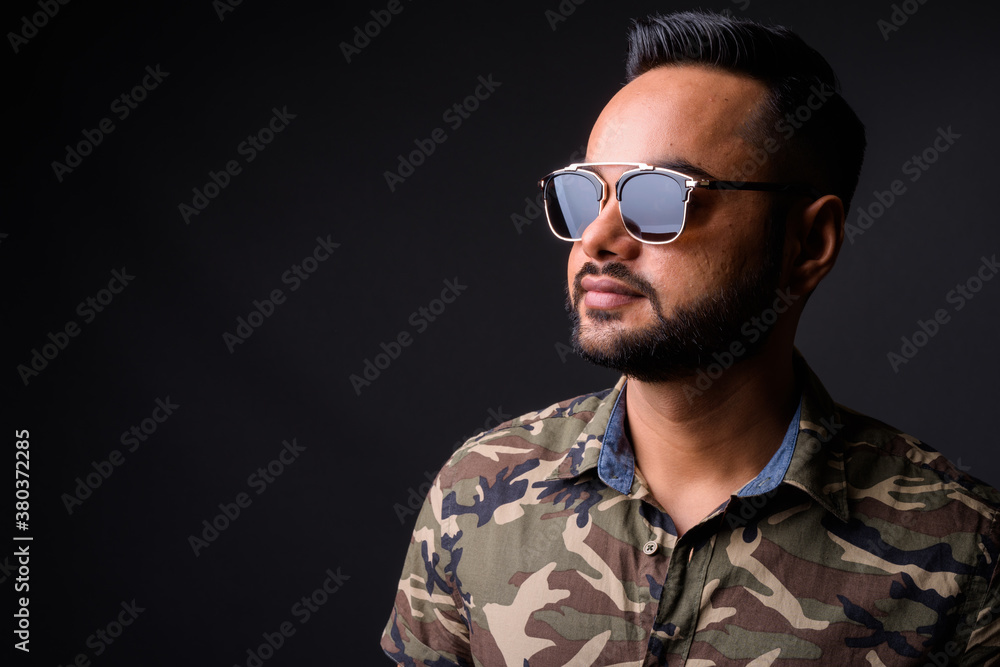 Young bearded Indian man against gray background Young bearded Indian man against gray background