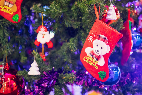 Decorated Christmas socks baubles on fir tree New Year holidays background