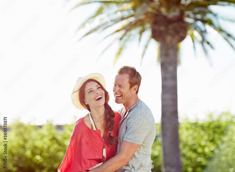 Beautiful couple relaxing and having fun by pool at luxury resort Beautiful couple relaxing and having fun by pool at luxury resort