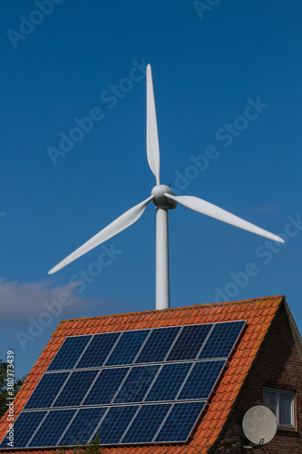 solar panels on a rooftop and wind turbine, climate compatibility, energy policy photo