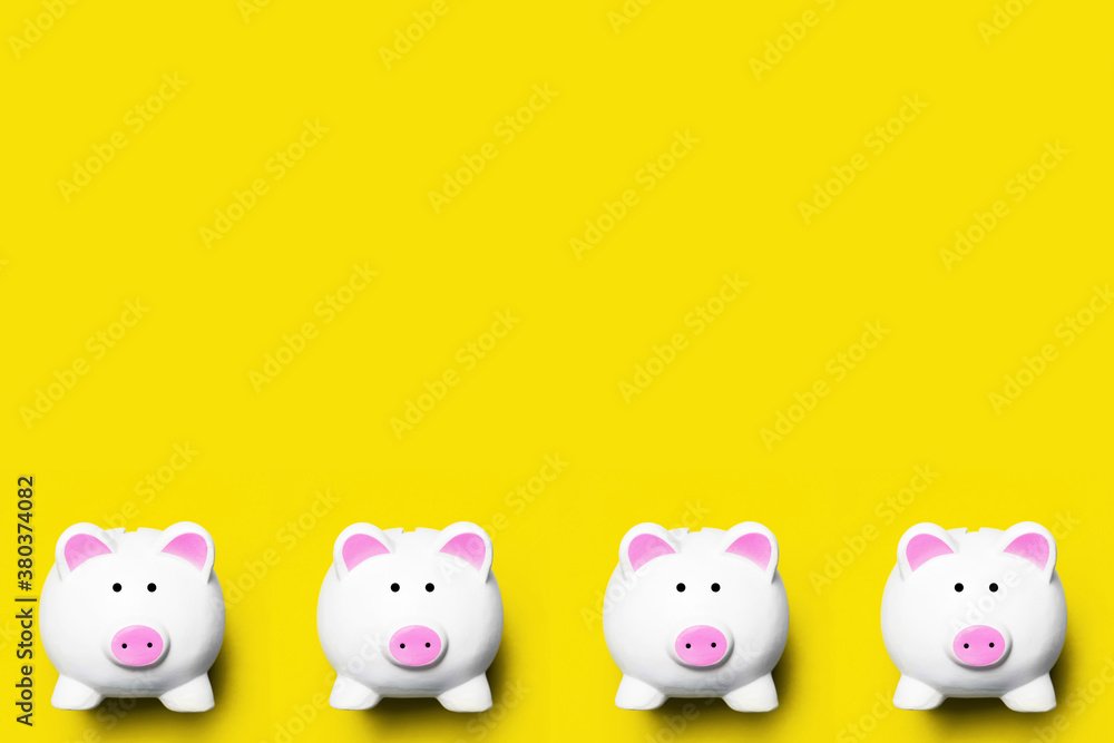 Money diversification background. Four piggy bank isolated on yellow. Home budget planning empty copy space. Coins and banknotes collecting. Cash saving backdrop. Money diversification background. Four piggy bank isolated on yellow. Home budget planning empty copy space. Coins and banknotes collecting. Cash saving backdrop.