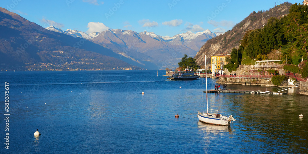 Panoramic view of the Como lake and mountain range at background near the small old city of Varenna in Italy in the winter season.