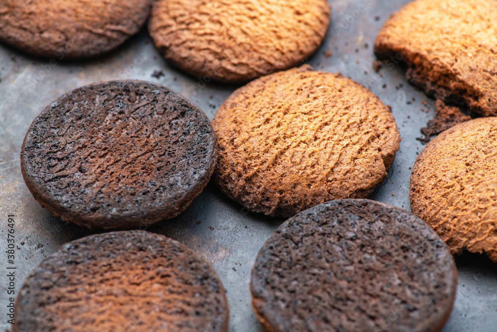 Burnt cookies. Burnt, burnt oatmeal cookies lie on a black baking sheet. Burnt cookies. Burnt, burnt oatmeal cookies lie on a black baking sheet.