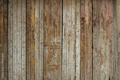 Wooden boards. Grunge texture of wooden boards. Abstract wooden background. The rough texture of the raw wood. Old fence made of wooden boards. Deep cracks. Remains of old paint on the boards 