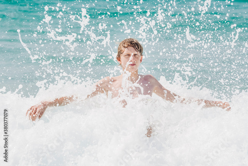 Teenage boy having fun in waves of Atlantic Ocean