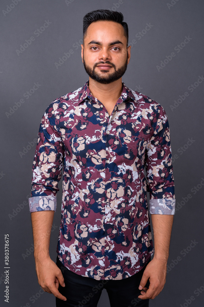 Fototapeta premium Young bearded Indian man against gray background