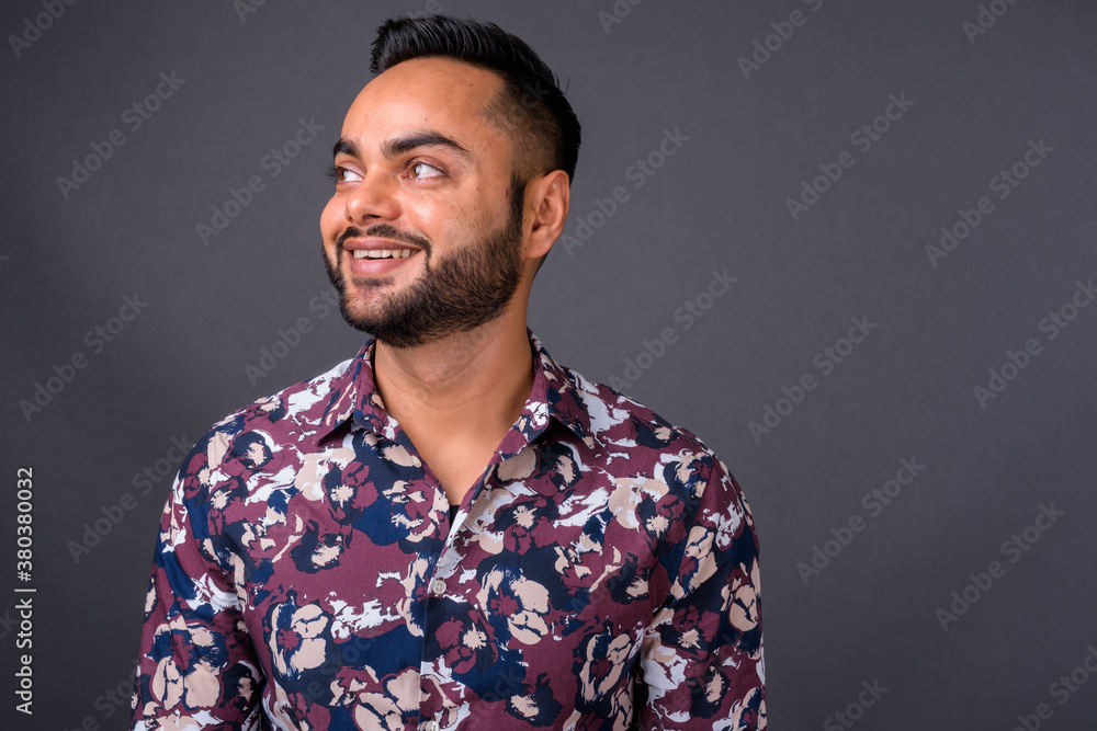 Fototapeta premium Young bearded Indian man against gray background