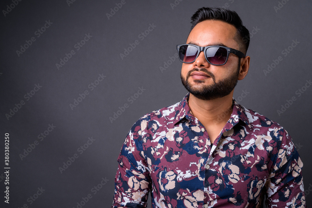 Fototapeta premium Young bearded Indian man against gray background