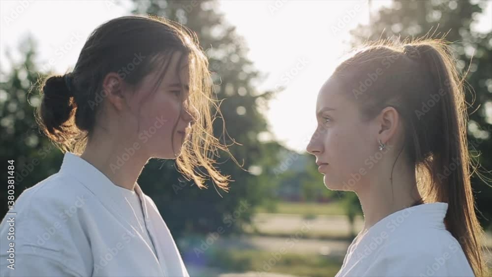 Battle of views. Two young girls in karate classes look into each other's eyes and one of them looks away. Side view. Close-up. Slow motion Battle of views. Two young girls in karate classes look into each other's eyes and one of them looks away. Side view. Close-up. Slow motion
