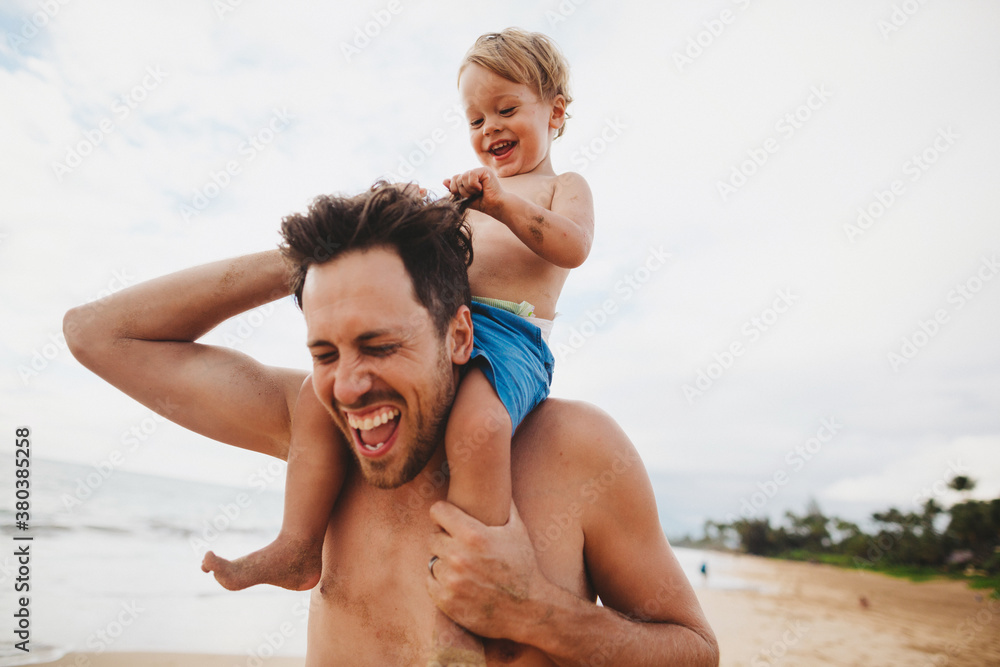 Young dad having fun with toddler son on tropical beach - kid pulling hair Young dad having fun with toddler son on tropical beach - kid pulling hair