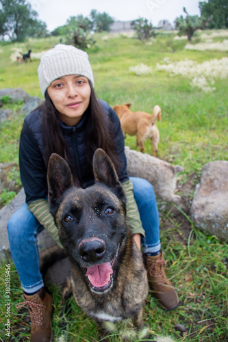 Canvas Print Portrait of a dutch shepherd dog and a woman in a grassy field