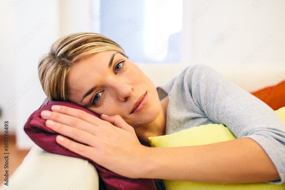 Young Woman Resting on a Couch with Colorful Cushions Young Woman Resting on a Couch with Colorful Cushions