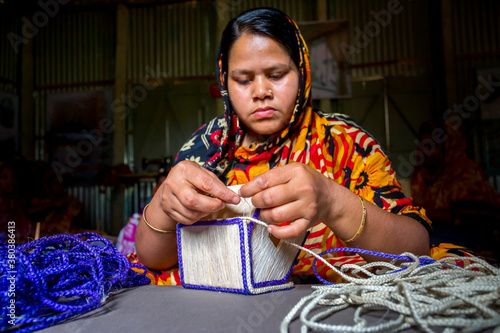 Bangladesh – May 13, 2018: A woman crafts maker is making a showpiece home from the fibers of a banana tree at Madhupur, Tangail. photo