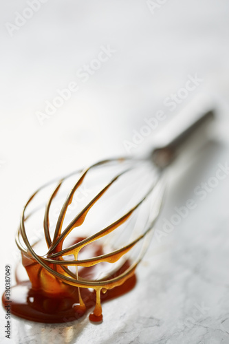 Dulce de leche dripping on whisk photo