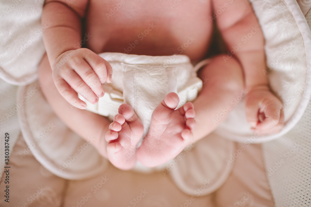 Newborn sitting in baby seat with hands and feet visible Newborn sitting in baby seat with hands and feet visible