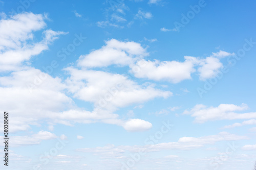 White cumulus clouds against the background against blue on a blue background.