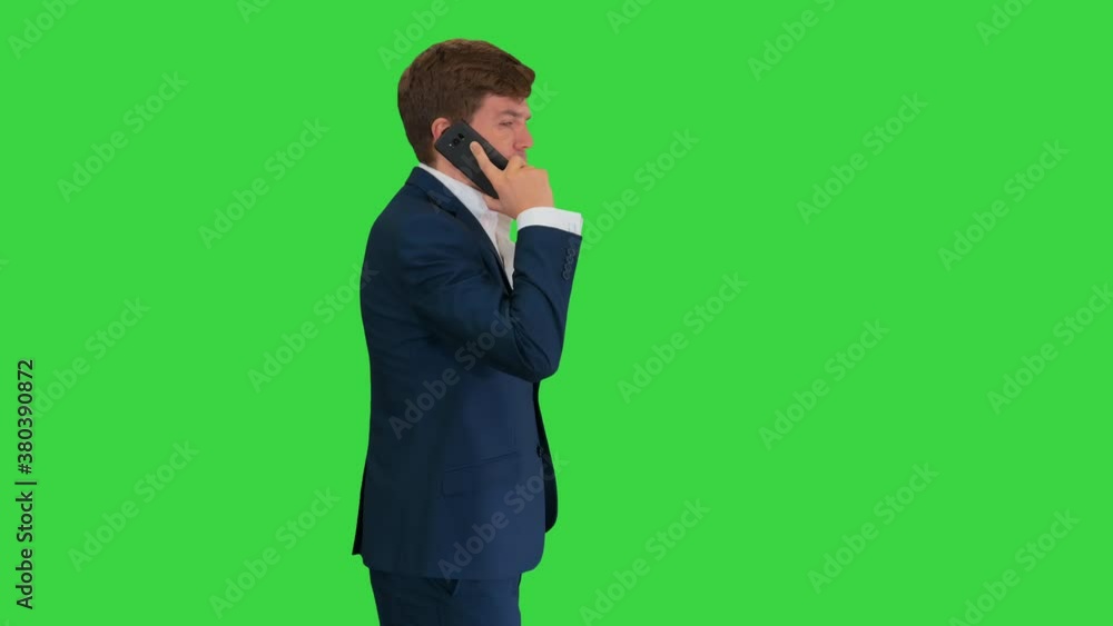 Handsome young businessman talking on the phone while walking on a Green Screen, Chroma Key. Handsome young businessman talking on the phone while walking on a Green Screen, Chroma Key.