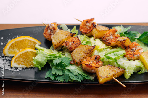 tiger prawns with pineapples in a black plate