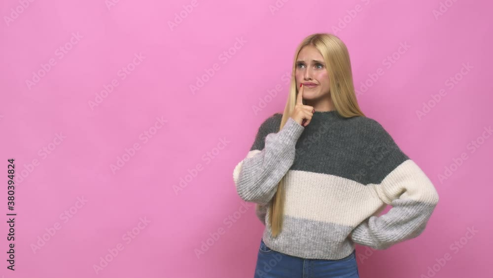 Young caucasian blonde woman looking sideways with doubtful and skeptical expression Young caucasian blonde woman looking sideways with doubtful and skeptical expression