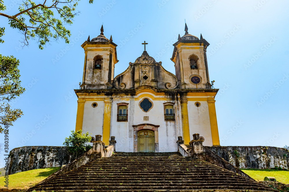 Ancient stairs and historic church of 18th century colonial architecture on top of the hill in the city of Ouro Preto in Minas Gerais, Brazil with the mountains behind
