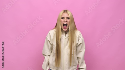 Young caucasian blonde woman screaming very angry and aggressive