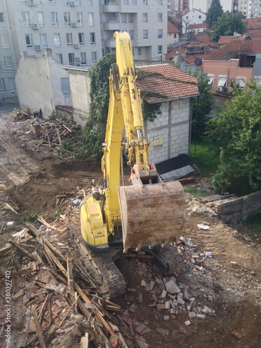 a yellow construction machine with a spoon digs a hole for a new building