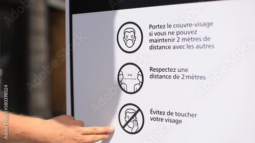 Selective focus of male hands pointing on banner poster with rules to follow in public place printed giving information to people regarding covid-19 photo