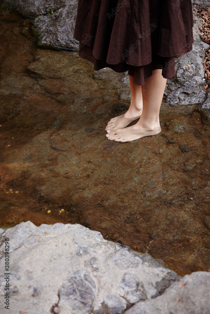 Woman with feet in water relaxing in nature in California Woman with feet in water relaxing in nature in California