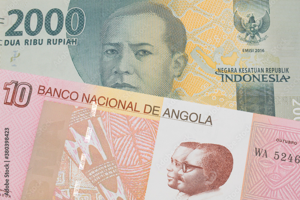 Fototapeta premium A macro image of a grey two thousand Indonesian rupiah bank note paired up with a colorful ten kwanza bank note from Angola. Shot close up in macro.