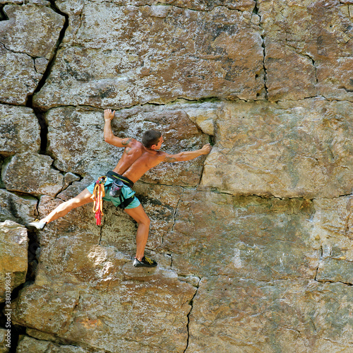 Rock climber traversing across rock face. photo