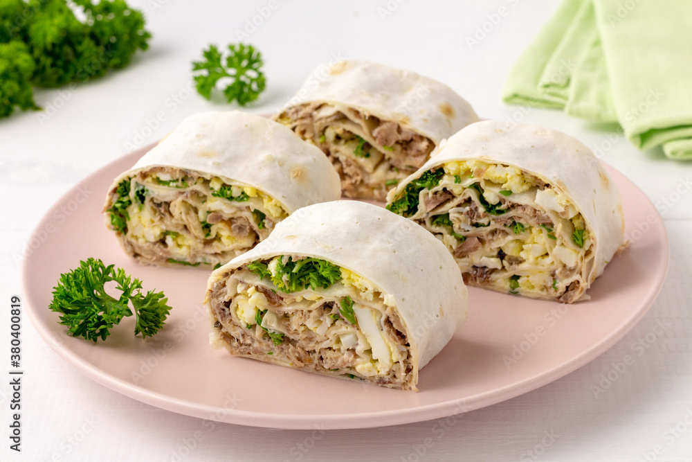 Lavash roll with fish, cheese, eggs and parsley on white background. Festive appetizer.