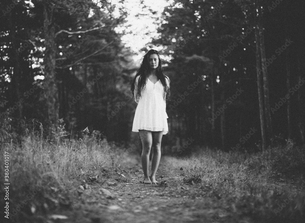 A beautiful young woman walks alone in a dark woods A beautiful young woman walks alone in a dark woods