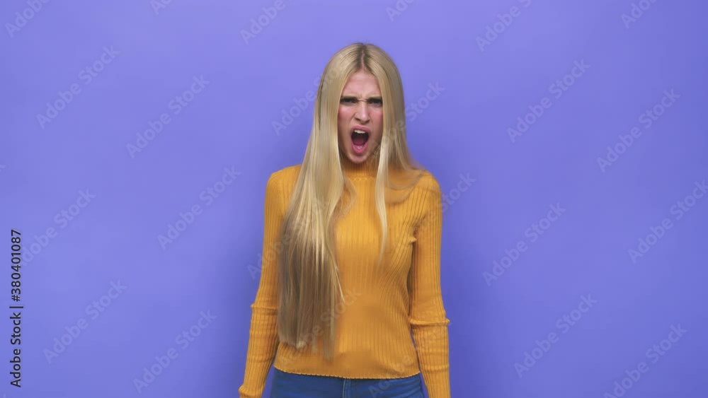 Young caucasian blonde woman screaming very angry and aggressive Young caucasian blonde woman screaming very angry and aggressive