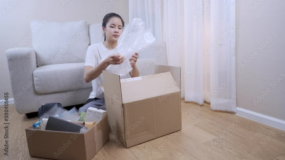 wide shot female buying new apartment, take stuff out of the parcel Storage box to arrange things, sit down couch behind, Multitasking works shore, Relocating moving in concept, stay at home, close up wide shot female buying new apartment, take stuff out of the parcel Storage box to arrange things, sit down couch behind, Multitasking works shore, Relocating moving in concept, stay at home, close up