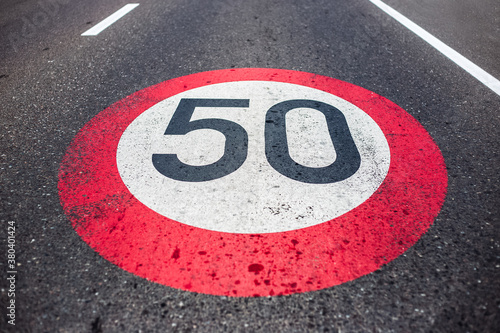 50km/h speed limit sign painted on asphalting road. © Lalandrew