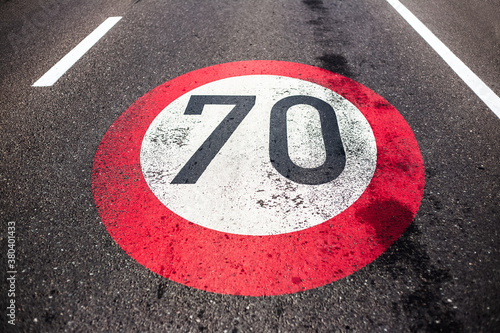 70km/h speed limit sign painted on asphalting road. © Lalandrew