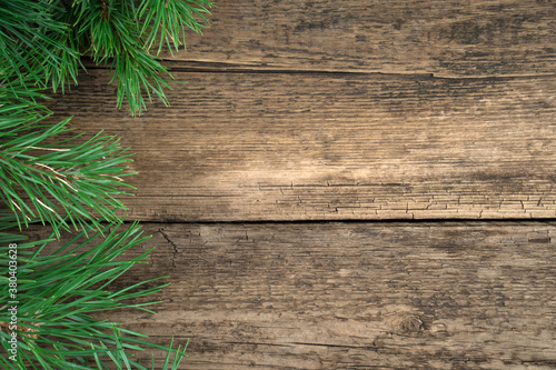 Christmas background made of fresh pine branches on a natural wooden background. Holiday background, top view. The concept of Christmas, New year.