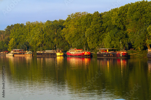 Avignon, France - 6/5/2015: A line of canal boats on the Rhone River in Avignon. Canal boat cruising in France is popular and diverse.