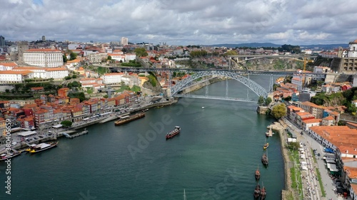 Dom Luis bridge city of Porto with cloudy sky and boats, located in Portugal.