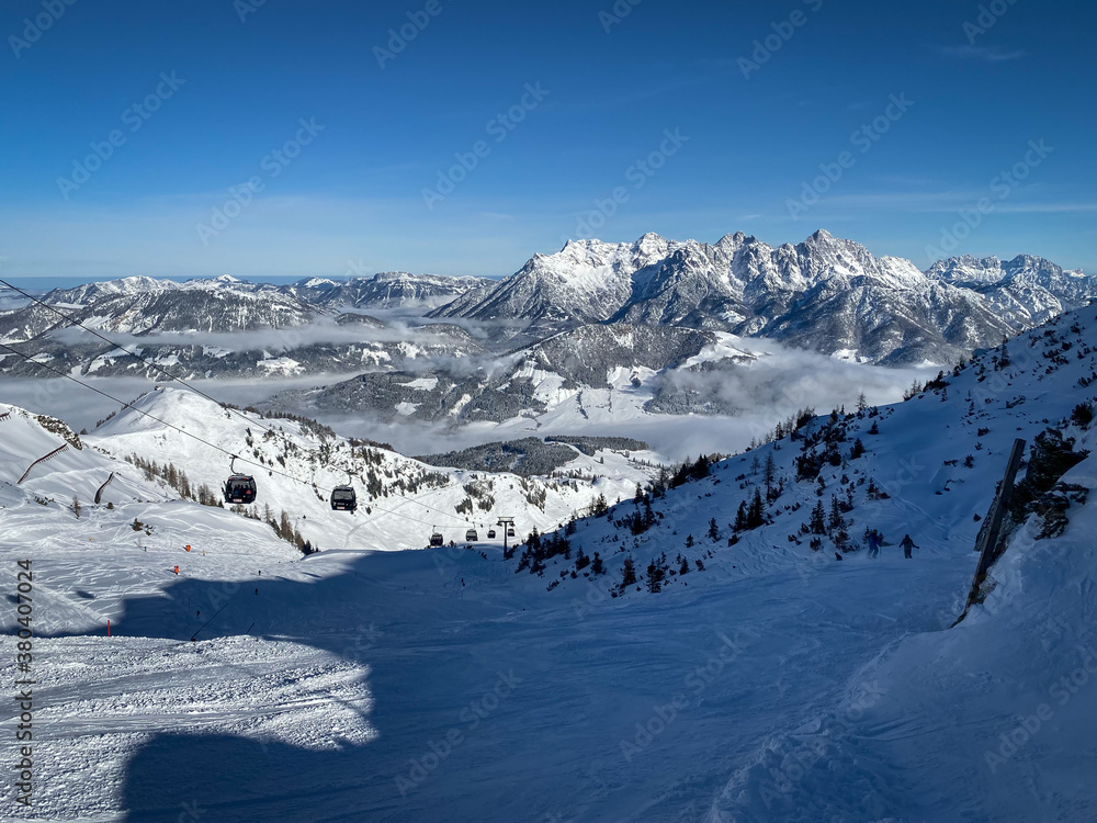 Scenic view Lofer Mountains and ski slopes of Fieberbrunn, Austria against blue sky.