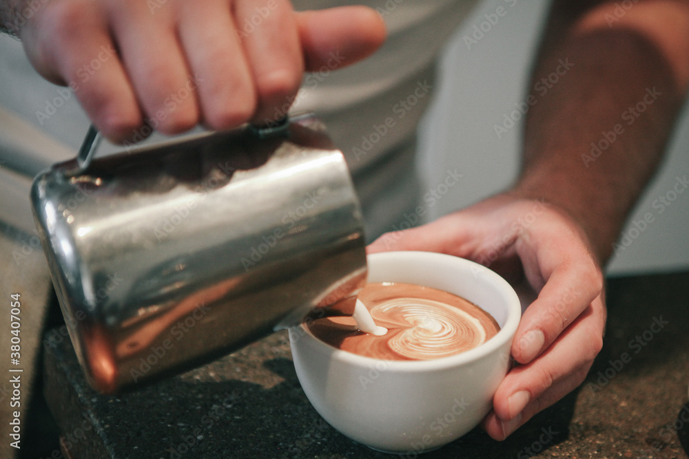 Close up of barista pouring milk into latte Close up of barista pouring milk into latte