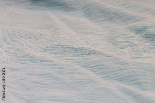 Texture background light blue color fabric closeup with folds